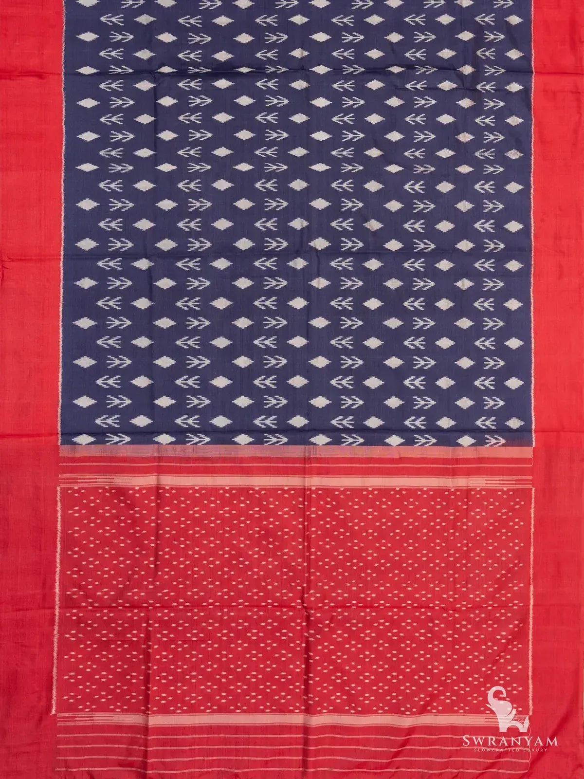 Navy blue Pochampally ikat silk saree spread flat showing white ikat body motifs, red borders and red dotted ikat pallu