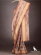 Full drape of handwoven cocoa brown ikkat silk saree showing pallu, pleats and wide antique gold border