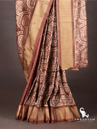 Pleats of cocoa brown Pochampally ikat silk saree with traditional white motifs and gold zari hem border