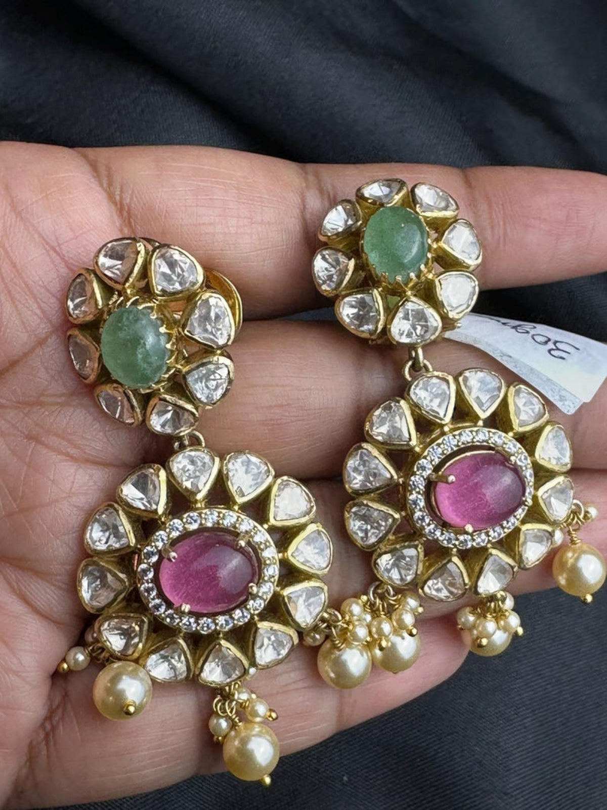 Swranyam Moissanite Polki silver earrings held in hand for size reference