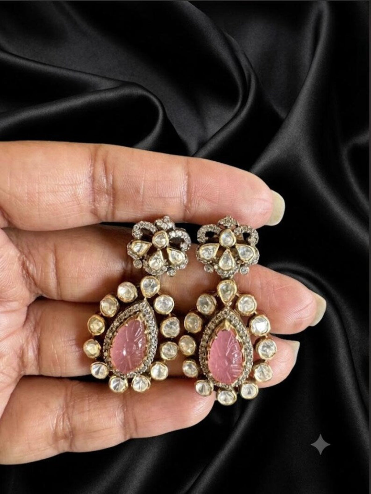 Swranyam silver Polki dangler earrings held in hand for size reference