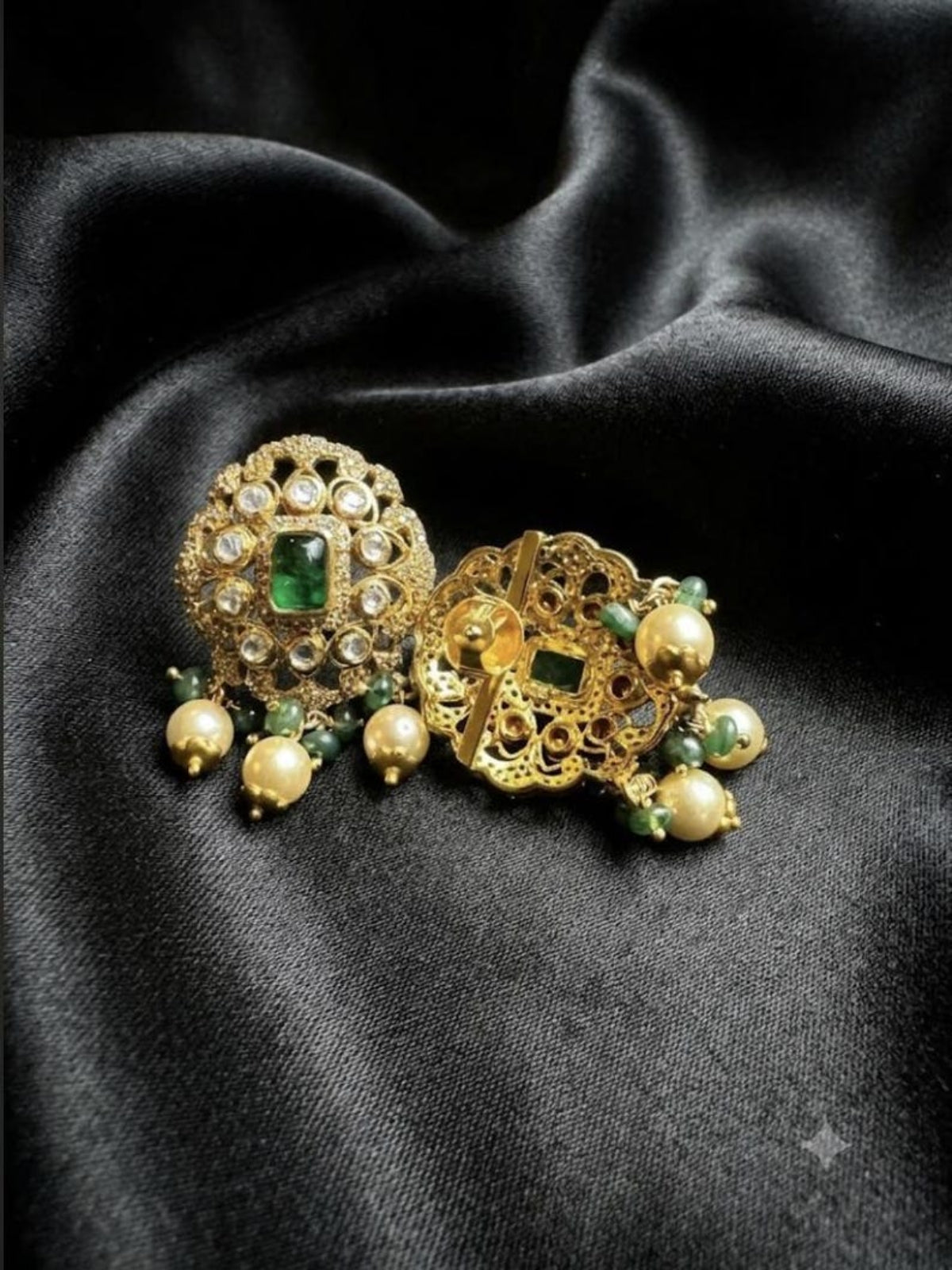Close-up of Swranyam Moissanite Polki earrings with emerald and pearl accents