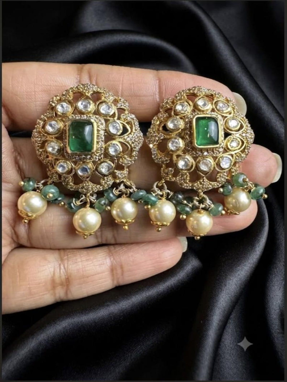 Swranyam silver Polki emerald pearl earrings held in hand for size reference