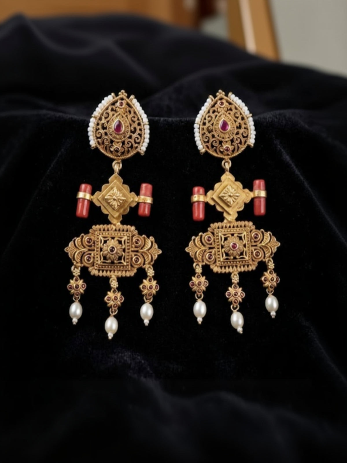 Swranyam 92.5 silver antique boho chandelier earrings with coral stone accents, on dark fabric background
